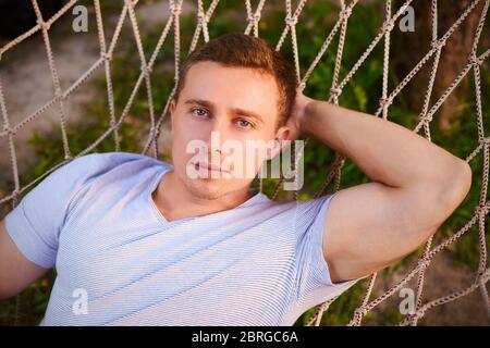 guy se reposer dans un jardin hamac. été vibes dans la forêt Banque D'Images