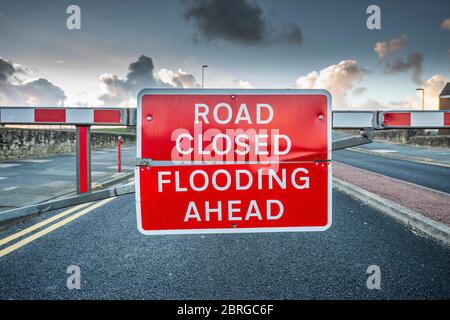 route devant fermée en raison du panneau d'avertissement d'inondation sur la barrière de l'autre côté de la route Banque D'Images