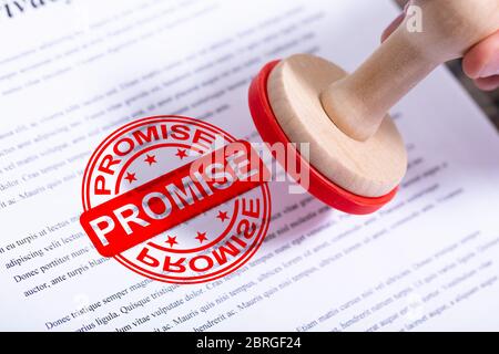 Businessman Hand Putting Promesse Stamp sur le document Banque D'Images