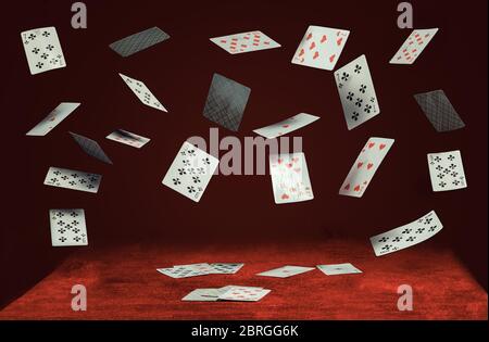 les cartes à jouer tombent sur une table avec un tissu rouge Banque D'Images