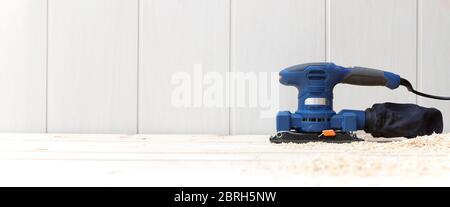 Détail d'une ponceuse électrique sur le plancher en bois naturel de sa maison. Espace pour le texte. Travail, décoration et bricolage. Banque D'Images