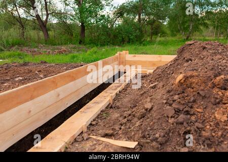 Coffrage en bois pour créer des fondations en bandes pour une nouvelle base de maison. Construction de maison depuis le concept de commencement Banque D'Images