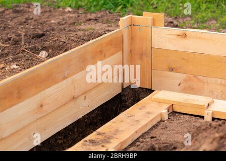 Coffrage en bois pour créer des fondations en bandes pour une nouvelle base de maison. Construction de maison depuis le concept de commencement Banque D'Images