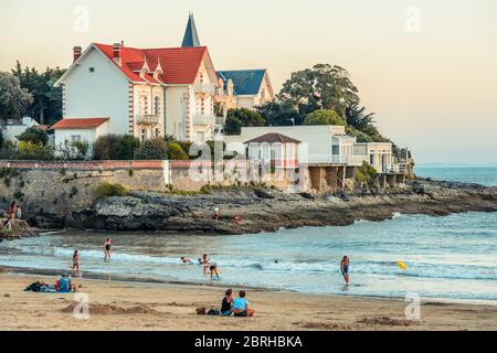 Saint-Palais-sur-Mer, France : quelques personnes s'apprécient sur la plage du Bureau au centre ville au coucher du soleil. Banque D'Images