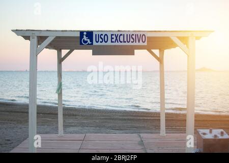 Arbor pour fauteuil roulant, usage exclusif à la plage de Los Narejos en Espagne. Endroits dans la plage pour les personnes avec des désabilitéle signe est bleu sur un bac blanc Banque D'Images