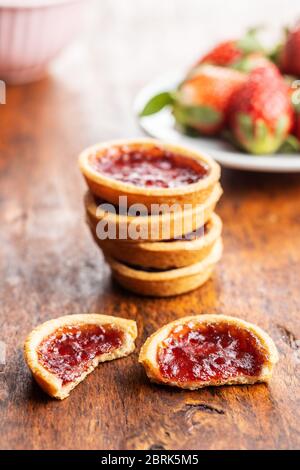 Biscuits sucrés avec confiture de fraises sur une table en bois. Banque D'Images