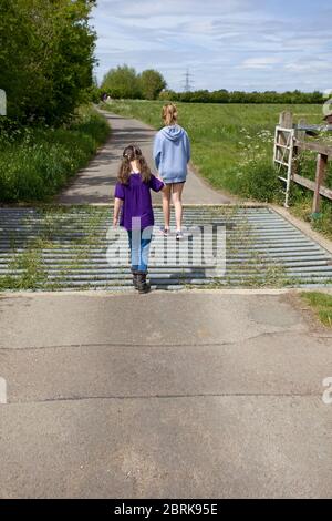 Deux jeunes filles traversant un cattlegrid, royaume-uni Banque D'Images