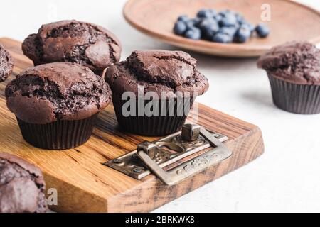 Délicieux muffins au chocolat maison sur bois rustique, bleuets d'été frais dans une plaque en céramique Banque D'Images