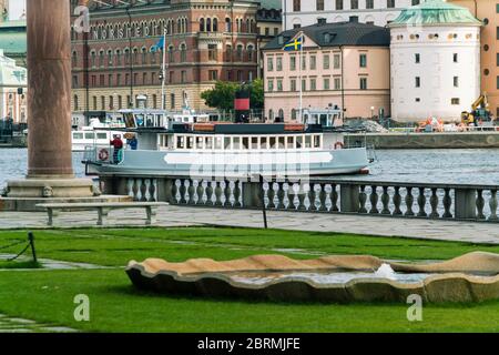 Parc de la ville de 'Stadshusparken' avec un ferry et Riddarholmen en arrière-plan Banque D'Images