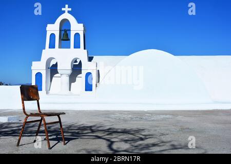 Beffroi traditionnel blanc et bleu avec croix et cloches de l'église orthodoxe grecque dans le village d'Oia, Santorini, Grèce Banque D'Images