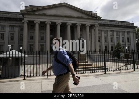 Washington, États-Unis. 21 mai 2020. Un homme passe devant le bâtiment du département du Trésor américain à Washington, DC, aux États-Unis, le 21 mai 2020. Le secrétaire au Trésor américain Steven Mnuchin a déclaré jeudi que l'administration examinera attentivement la situation économique dans les prochaines semaines et qu'il pense qu'il y a une « probabilité élevée » que le pays aura besoin d'un autre projet de loi d'allègement de la COVID-19. Crédit : Ting Shen/Xinhua/Alay Live News Banque D'Images