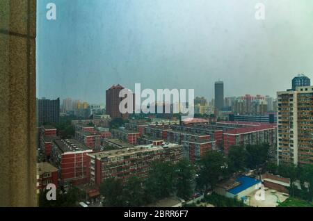 Beijing Chine tirer à travers le verre sale d'une chambre d'hôtel donnant sur la ville lors d'une journée de ciel Banque D'Images