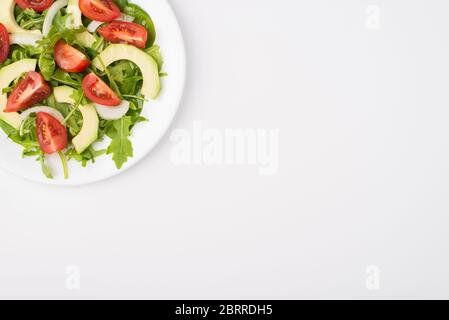 Concept de régime alimentaire sain. Vue rapprochée en haut au-dessus de la tête photo d'une assiette à salade avec de l'huile d'olive dans le coin supérieur gauche isolé sur fond blanc Banque D'Images