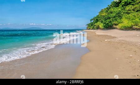 Une belle plage déserte, comme une marée basse laisse du sable humide sur le côté nord de l'île Mindoro près d'Abra de Ilog, Philippines. Banque D'Images