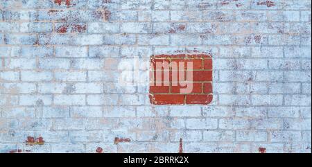 Mur de briques peint en blanc avec une pièce de briques rouges Banque D'Images