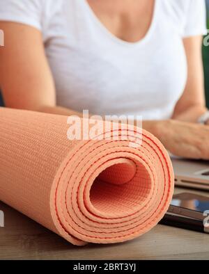 Concept d'affaires et de mode de vie sain. Tapis de yoga sur un bureau vue rapprochée, femme en forme sur le lieu de travail Banque D'Images