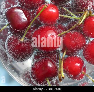 Les cerises douces et bulles dans l'eau Banque D'Images