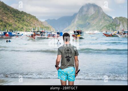 Scène matinale à la plage principale d'El Nido, Philippines, alors que les touristes commencent à partir sur les bateaux de jour. Banque D'Images