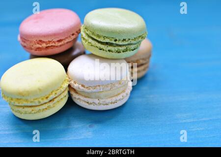 Pile de macarons colorés sur fond bleu. Gros plan, copie de texte. Banque D'Images