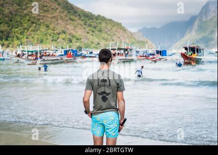 Scène matinale à la plage principale d'El Nido, Philippines, alors que les touristes commencent à partir sur les bateaux de jour. Banque D'Images