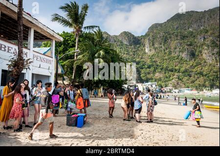 Scène matinale à la plage principale d'El Nido, Philippines, alors que les touristes commencent à partir sur les bateaux de jour. Banque D'Images