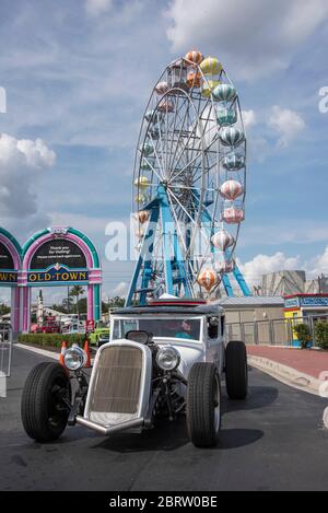 Hot Rod passe devant Funfair lors de la croisière en voiture du samedi dans la vieille ville de Kissimmee, Floride, États-Unis. Banque D'Images