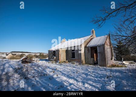 Maison abandonnée dans un cadre rural enneigé dans la campagne de Lamarkshire en Écosse. Banque D'Images