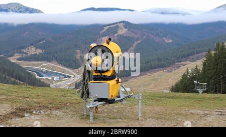 Mitrailleuse, canon à neige pour la production de neige artificielle en montagne, préparation au ski. Faire de la neige. Production de neige par pompage d'eau a Banque D'Images