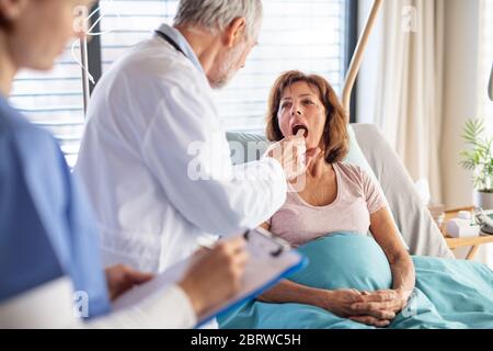 Médecin senior étudiant une patiente à l'hôpital. Banque D'Images