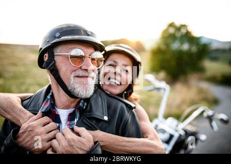 Un couple senior joyeux avec moto à la campagne. Banque D'Images