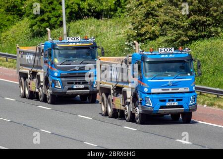 Deux camions de livraison Fox Haulage, camion, transport, camion, transporteur de marchandises, véhicule Volvo, transport commercial européen, industrie étroite, M61 à Manchester, Royaume-Uni Banque D'Images