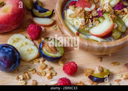 Muesli aux fruits rouges, des fruits et du lait - mettre en place et un petit-déjeuner sain. Ingrédients dispersés et des tranches de fruits Banque D'Images