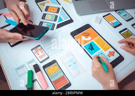 Le concepteur Web travaille sur une interface vers les applications de téléphonie mobile. Le développeur dessine des croquis des applications utilisateur pour smartphones. Banque D'Images