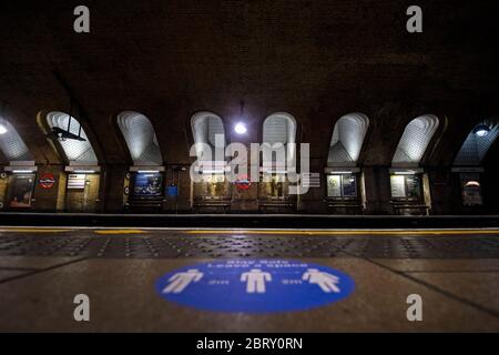 Un autocollant d'information sur les règles de distance sociale sur une plate-forme à la station de métro Baker Street à Londres le jour de Sherlock Holmes, après l'introduction de mesures pour sortir le pays du confinement. Banque D'Images