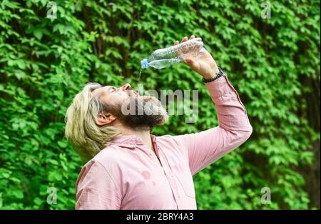 Buvez tout jusqu'à la dernière goutte. Concept d'équilibre entre les soins de santé et l'eau. Besoin d'étancher la soif. Rafraîchissez-vous par temps chaud. Hydratez la bouche sèche. Homme mûr barbu un peu d'eau. Banque D'Images