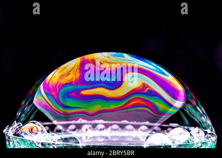Gros plan Kaléidoscope de bulles colorées tourbillonnantes photographiées en studio avec un fond noir Banque D'Images