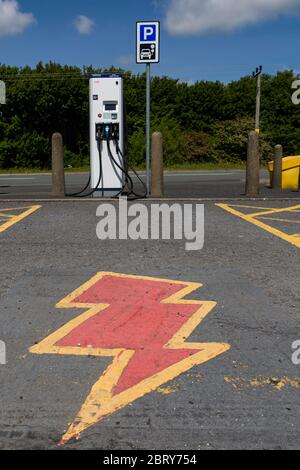 Point de charge de voiture électrique avec symbole d'éclair peint au sol Banque D'Images