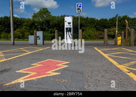 Point de charge de voiture électrique avec symbole d'éclair peint au sol Banque D'Images