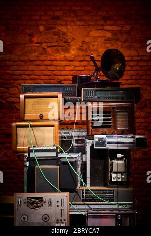Tour construite à partir de radios analogiques anciennes, d'amplificateurs, d'enregistreurs à cassettes et d'un phonographe. Groupe d'anciens appareils électroniques. Vieille brique Banque D'Images