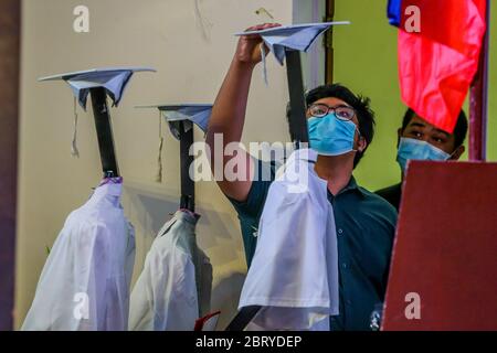 Manille. 22 mai 2020. Un membre du personnel de l'école prépare un robot lors d'une cérémonie de « cyber-remise des diplômes » dans une école secondaire de Manille, aux Philippines, le 22 mai 2020. Quelque 179 étudiants ont participé à la cérémonie de « cyber-remise des diplômes » au moyen de robots et de médias sociaux, l'interdiction des rassemblements de masse étant toujours mise en œuvre aux Philippines pour empêcher la propagation de la COVID-19. Crédit: Rouelle Umali/Xinhua/Alay Live News Banque D'Images