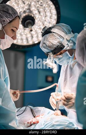 Équipe de femmes chirurgiens dans la salle d'opération. Une équipe moderne de médecins pendant une opération ancologique. Lutte contre le cancer. Plastique reconstructive Banque D'Images