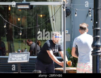 Le personnel sert des boissons à emporter à l'extérieur du pub Althorp, à Wandsworth, Londres, après l'introduction de mesures pour sortir le pays du confinement. Banque D'Images