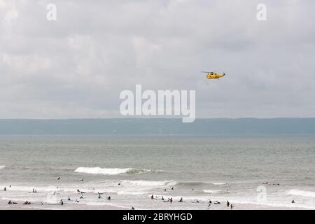 RAF Westland WS-61 Sea King hélicoptère de recherche et sauvetage en patrouille pour vérifier tout est bien avec les surfeurs et les nageurs sur la plage de Croyde Bay, Devon. Banque D'Images