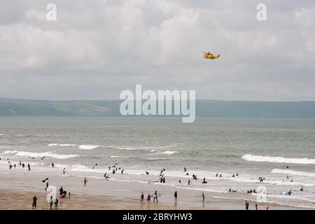 RAF Westland WS-61 Sea King hélicoptère de recherche et sauvetage en patrouille pour vérifier tout est bien avec les surfeurs et les nageurs sur la plage de Croyde Bay, Devon. Banque D'Images