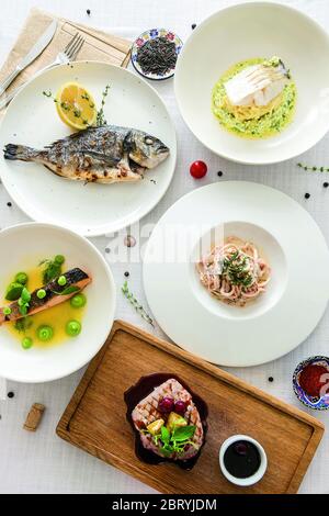 beaucoup de plats de poisson sur table blanche. Vue de dessus Banque D'Images