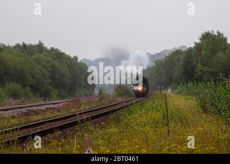 BR Standard classe 7 70013 locomotive à vapeur Oliver Cromwell passant par Mirfield, lors d'une soirée terne tirant le Scarborough Flyer en route vers Crewe. Banque D'Images