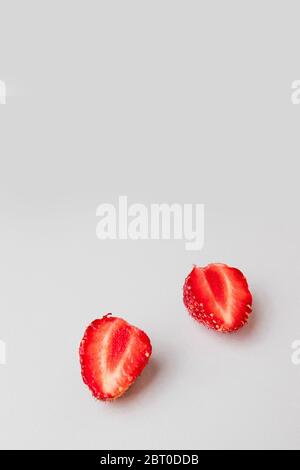 Demi-fraises sur fond gris. Photo verticale Banque D'Images