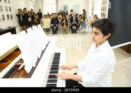 Petit garçon jouant du piano à la maison . Piano blanc . Azerbaïdjan Bakou 21.02.2020 . Banque D'Images