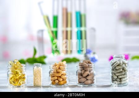 Concept de phytothérapie et compléments alimentaires. Phytothérapie comprimés secs avec des herbes naturelles sur fond de couleur légèrement. Banque D'Images