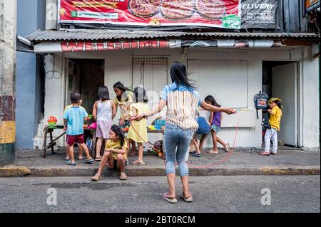 De jeunes enfants philippins jouent dans la rue de la vieille ville fortifiée d'Intramuros, Manille, Philippines. Banque D'Images